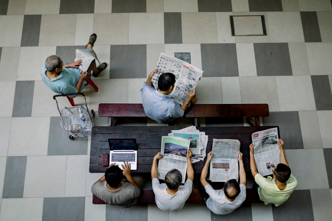 Elderly men reading newspapers